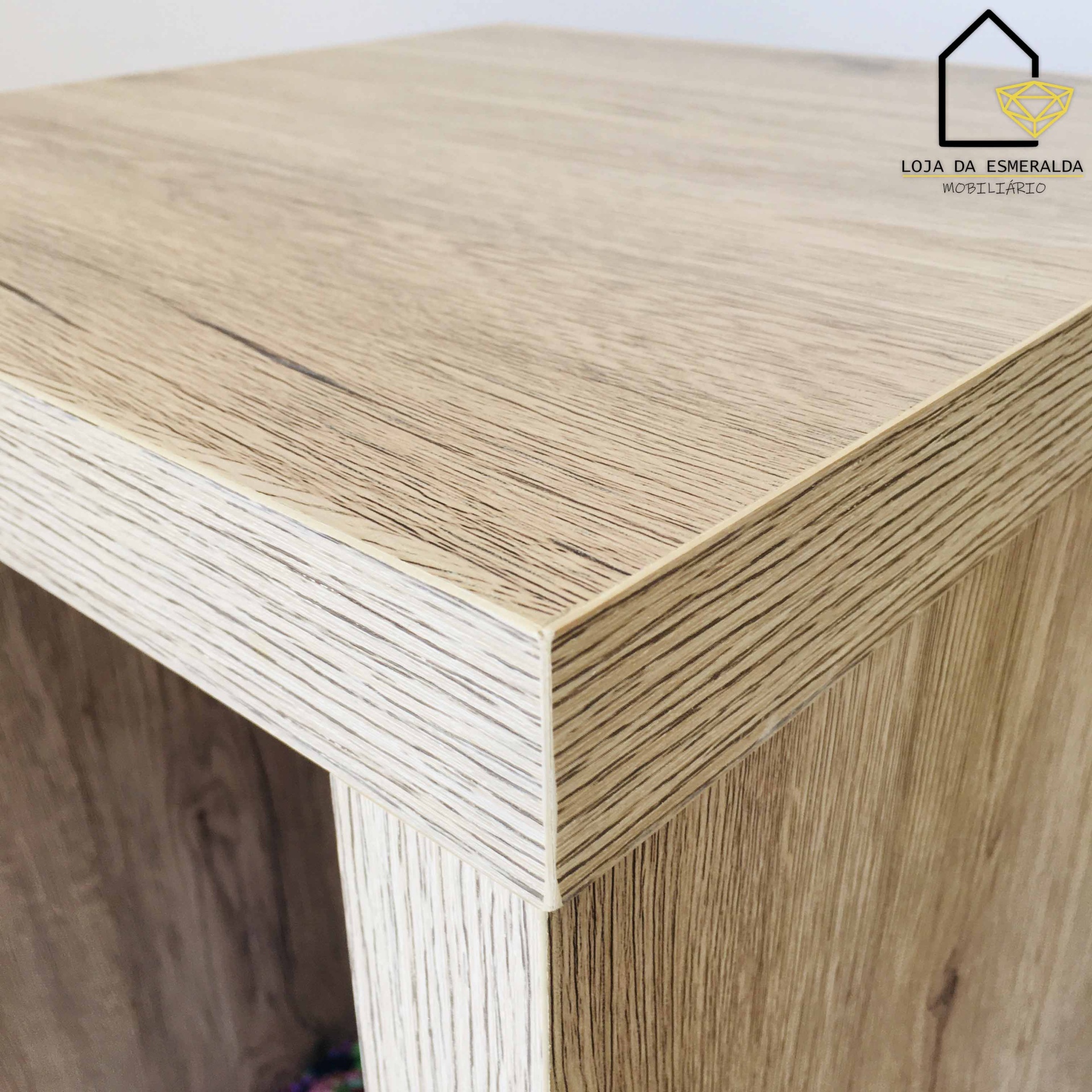 Canto superior de móvel em madeira clara com textura com logo no canto