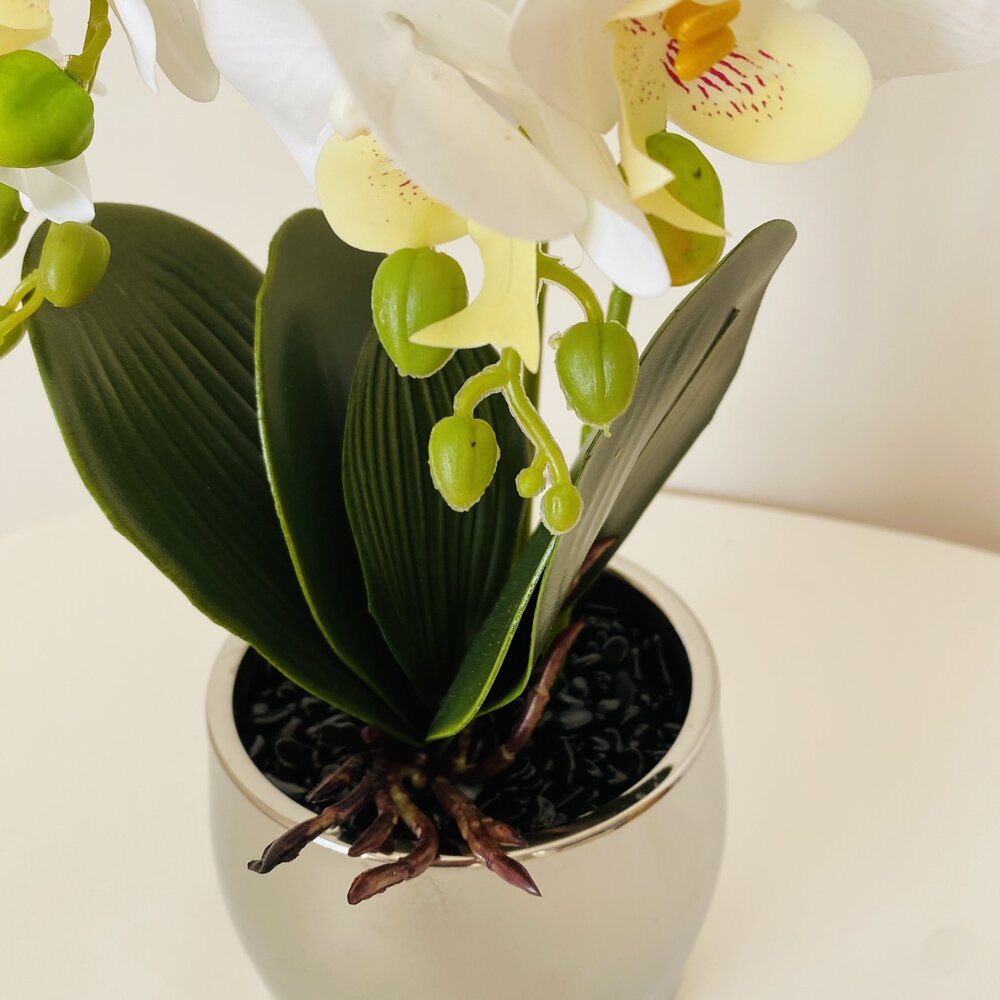 Planta artificial de orquídea branca em vaso prateado