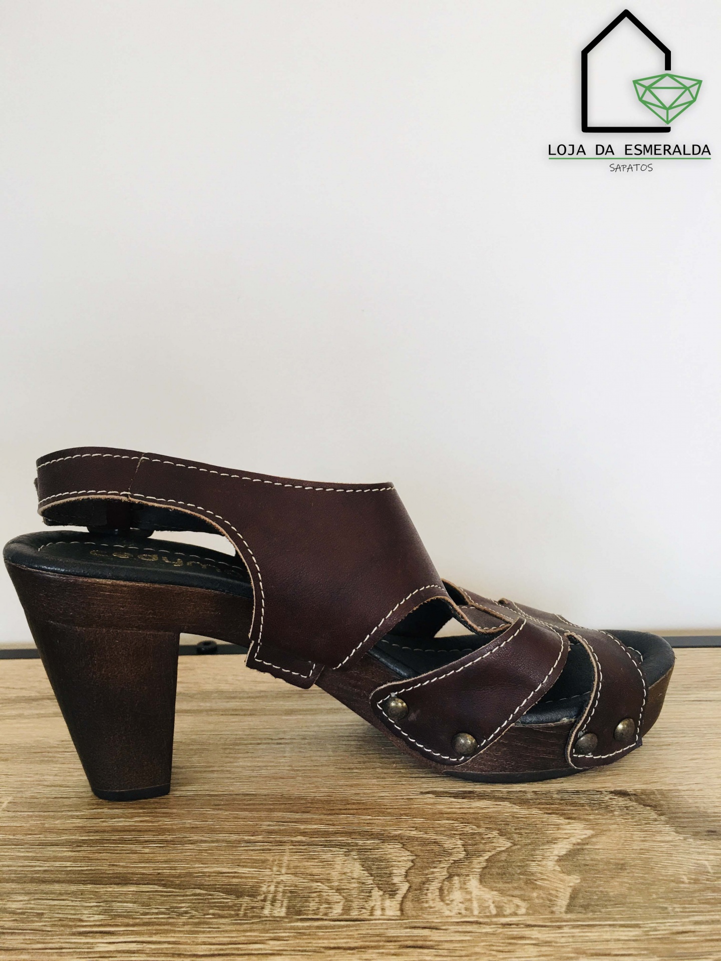 Sandália castanha de salto alto de senhora em fundo branco com logo