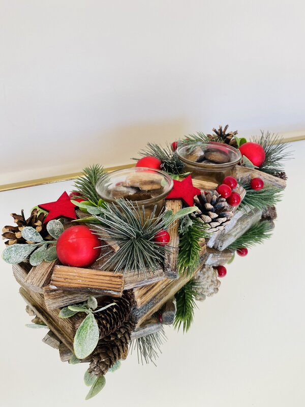 Arranjo decorativo de Natal em madeira com pinhas, folhas, bagas e estrelas vermelhas e velas em copos de vidro