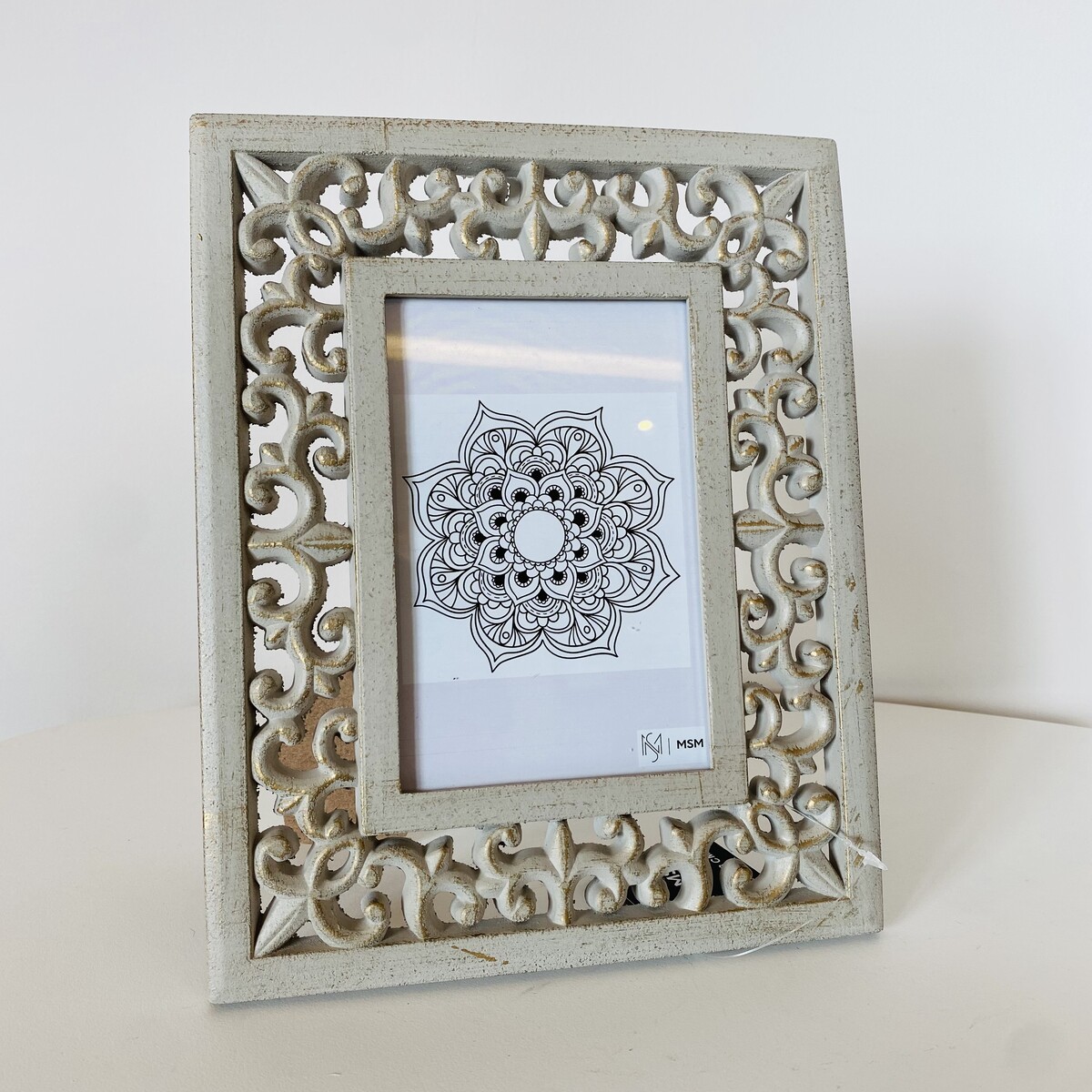 Moldura fotográfica branca decorativa com entalhes e desenho de mandala