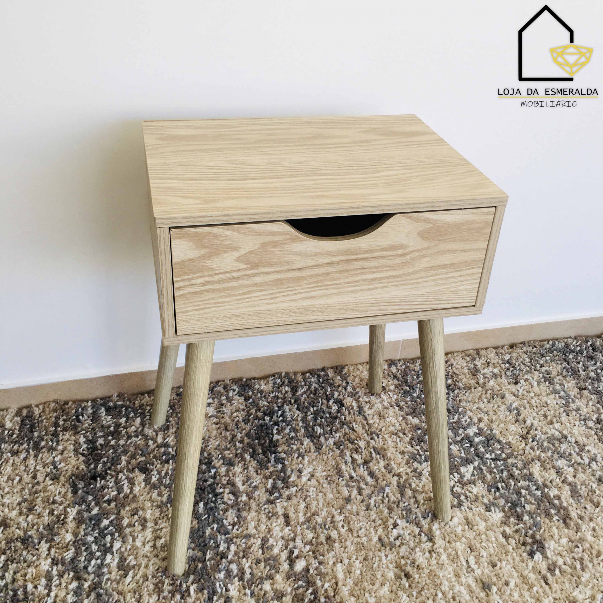 Mesa de cabeceira de madeira clara com gaveta e pernas cónicas