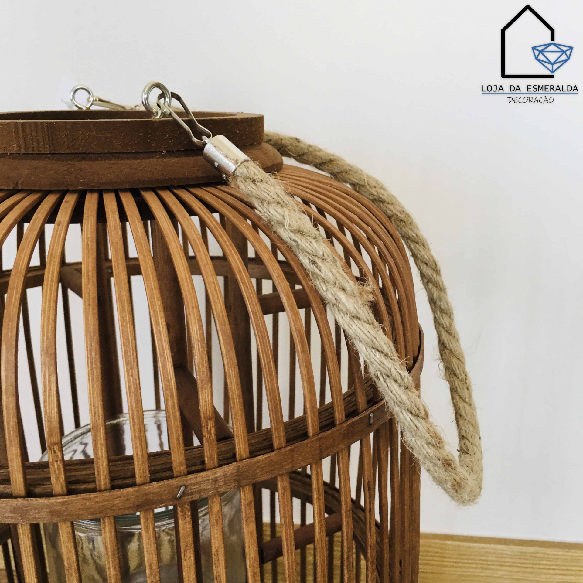 Lanterna de vime marrom com alça de corda natural em parede branca
