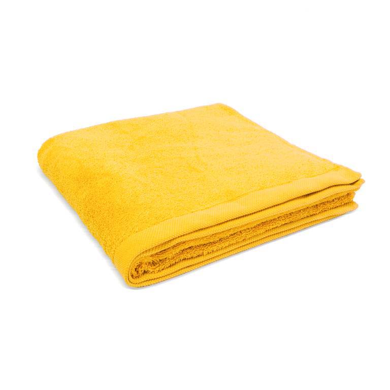 Toalha de banho amarela dobrada sobre fundo branco