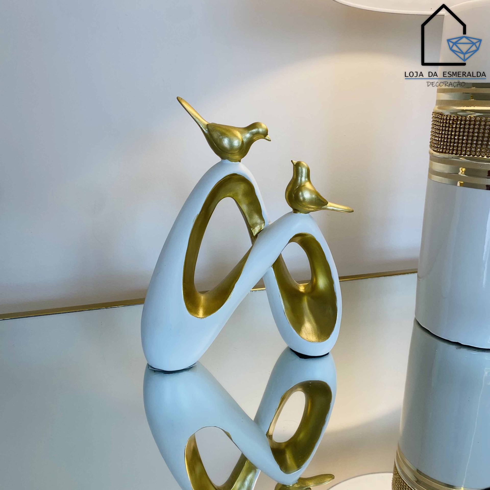 Estatueta decorativa branca e dourada com pássaros em forma de infinito