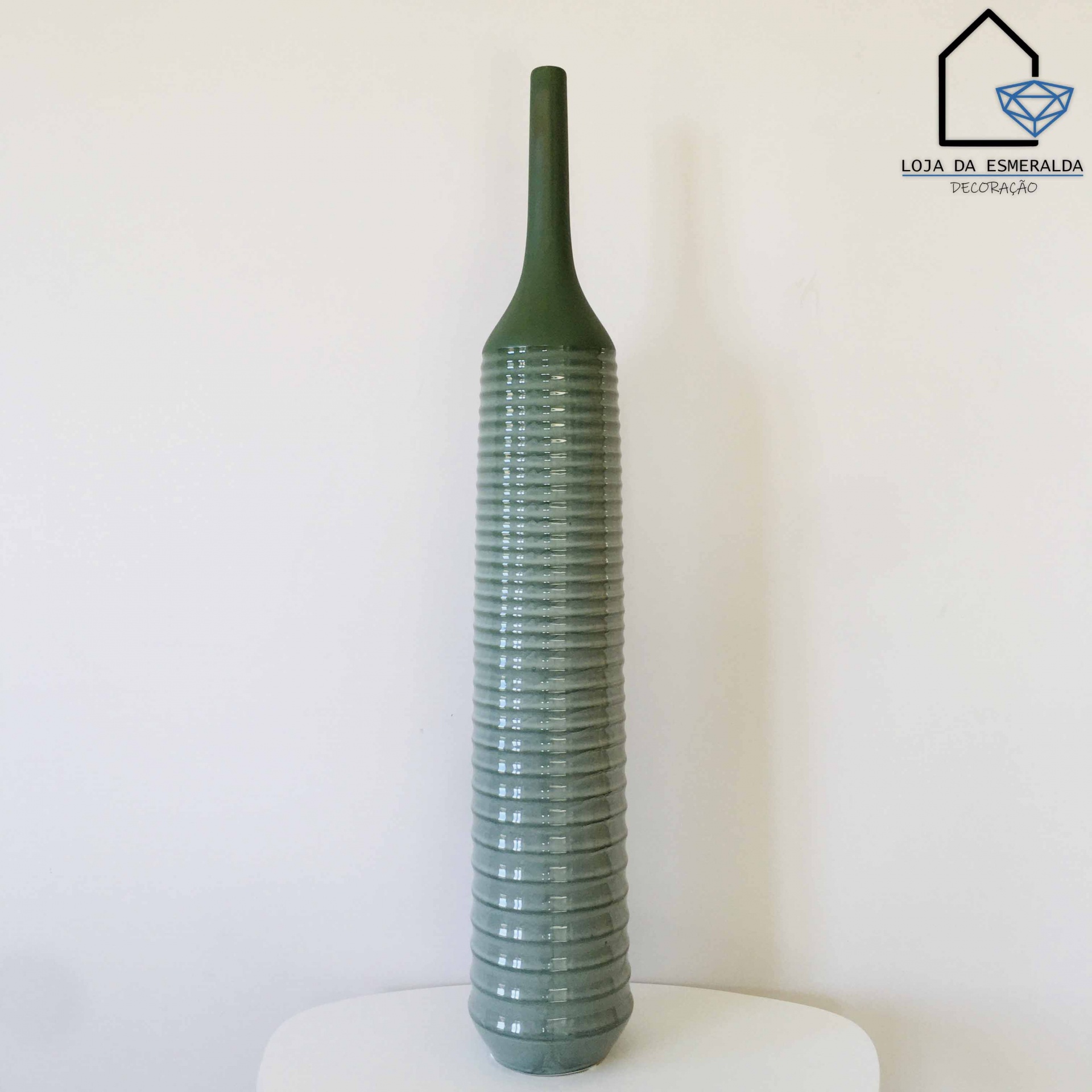 Garrafa decorativa alta verde em cerâmica com textura estriada.