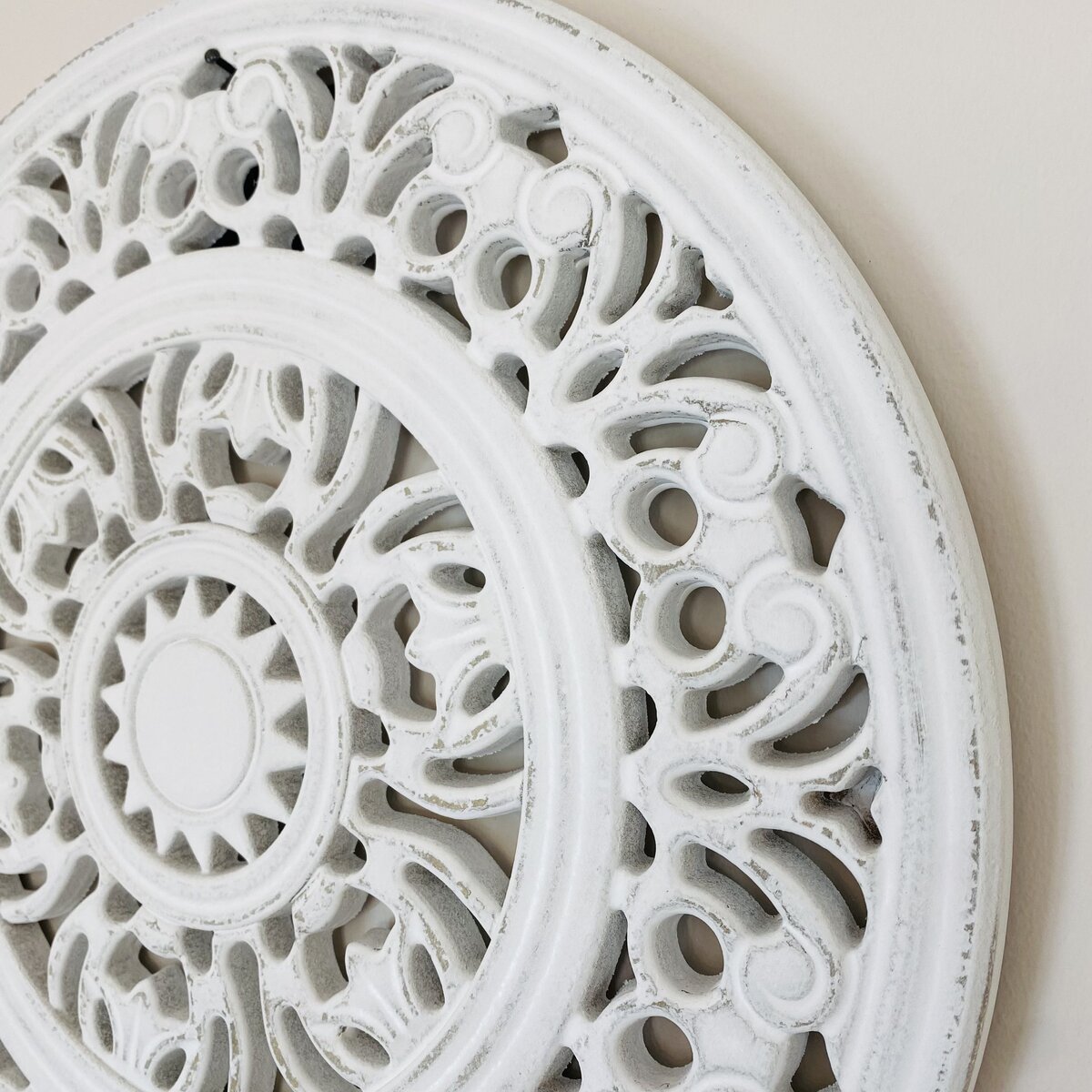 Decoração de parede circular em madeira branca com padrão recortado