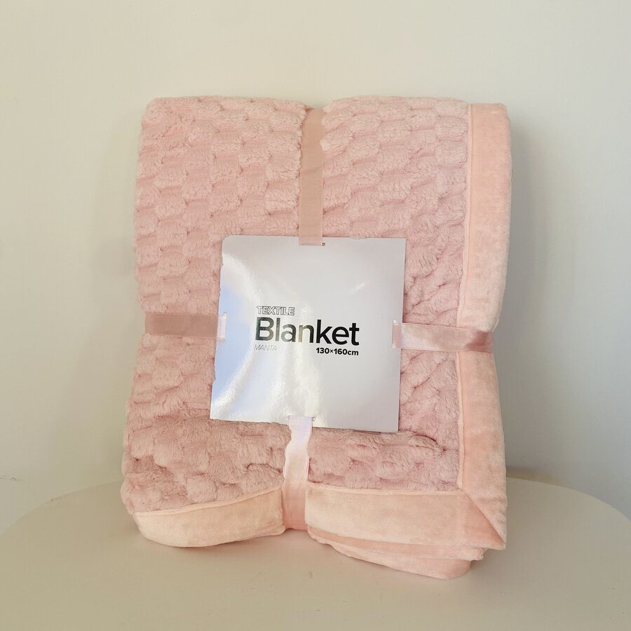 Cobertor rosa claro com etiqueta 'Winter Blanket 130x150cm' dobrado em mesa clara