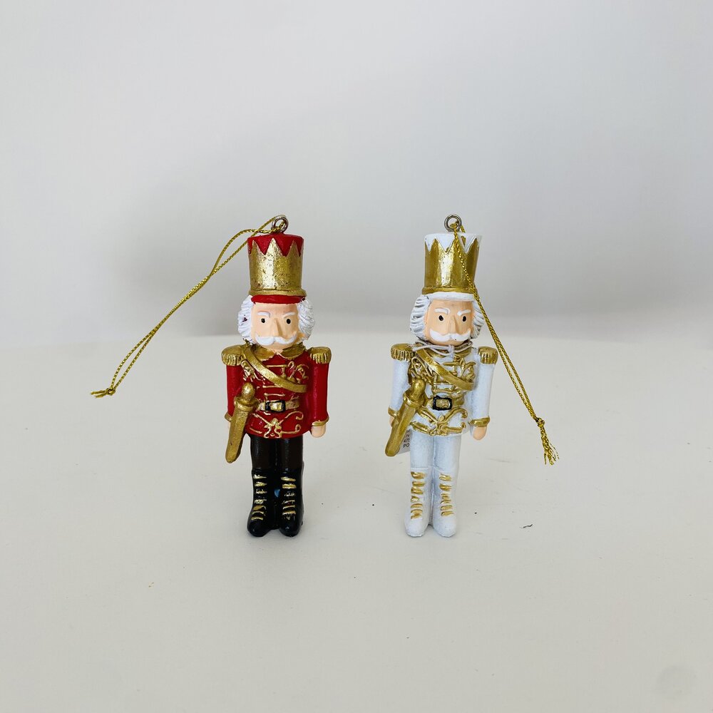 Duas figuras decorativas de soldado do rei, uma vermelha e outra branca, com coroas douradas