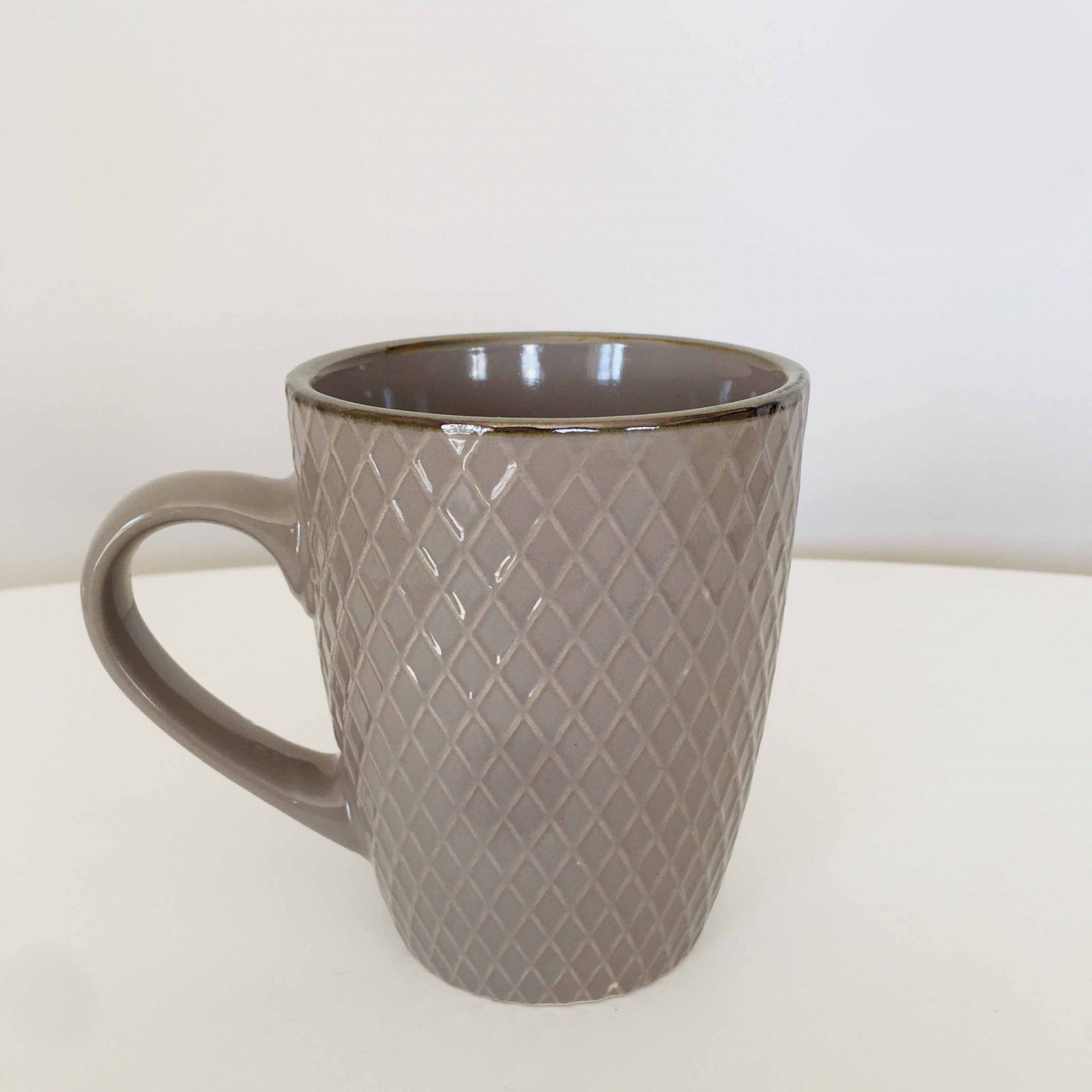 Caneca castanha com padrão de losangos em relevo