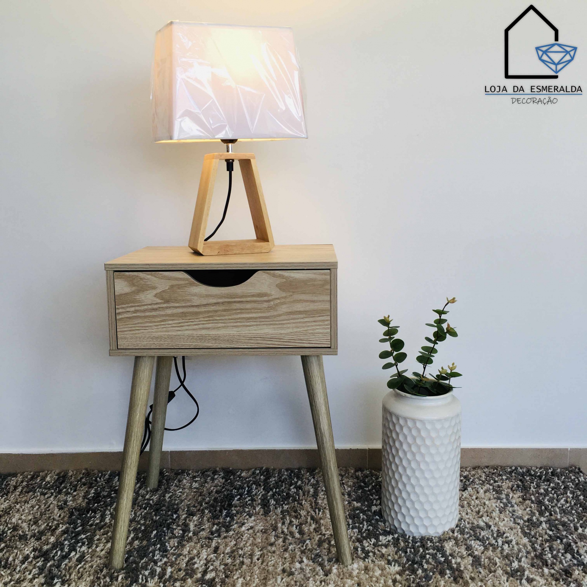 Mesa de apoio de madeira com luminária e vaso decorativo em ambiente interior