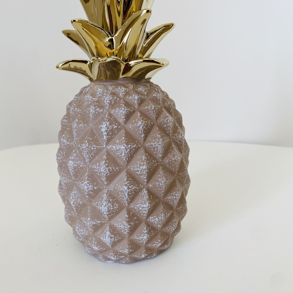 Objeto decorativo em forma de ananás cor-de-rosa com coroa dourada