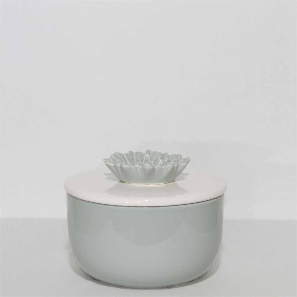 Pote cinza com tampa branca e flor cinza decorativa no centro