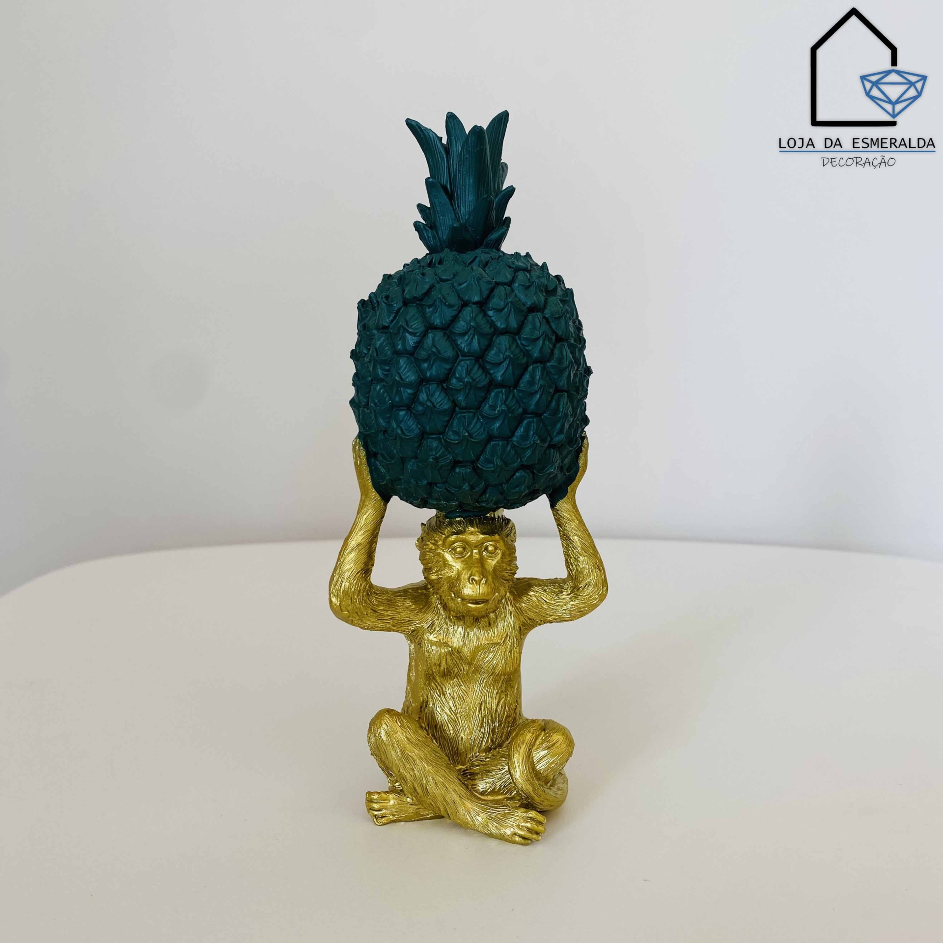 Escultura decorativa de macaco dourado com abacaxi verde