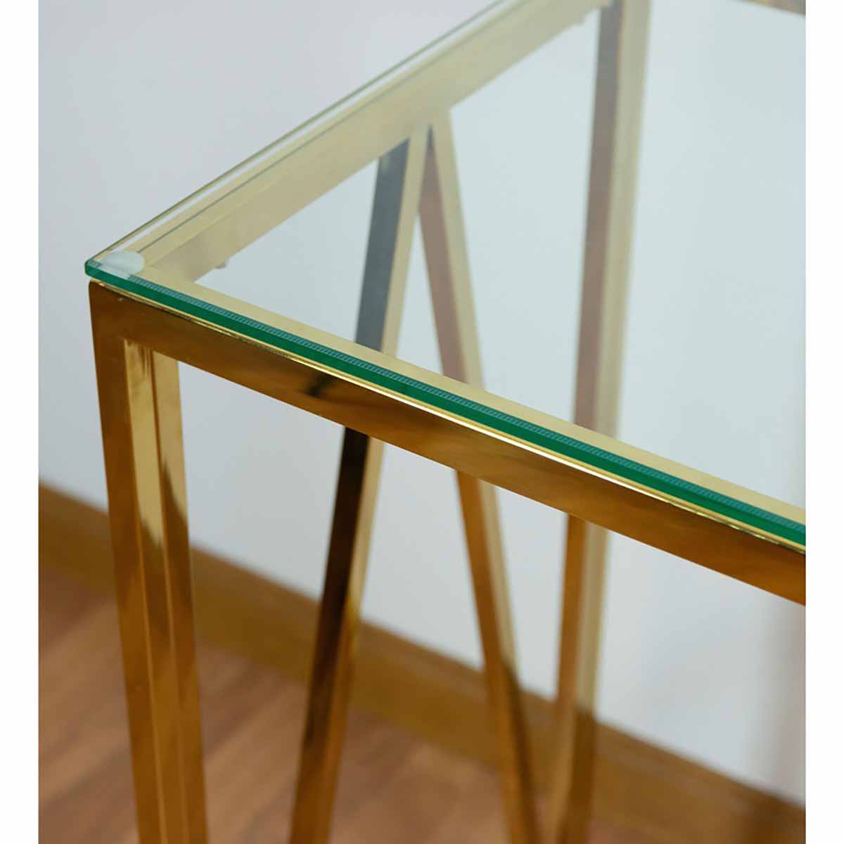 Mesa com estrutura dourada e tampo de vidro transparente