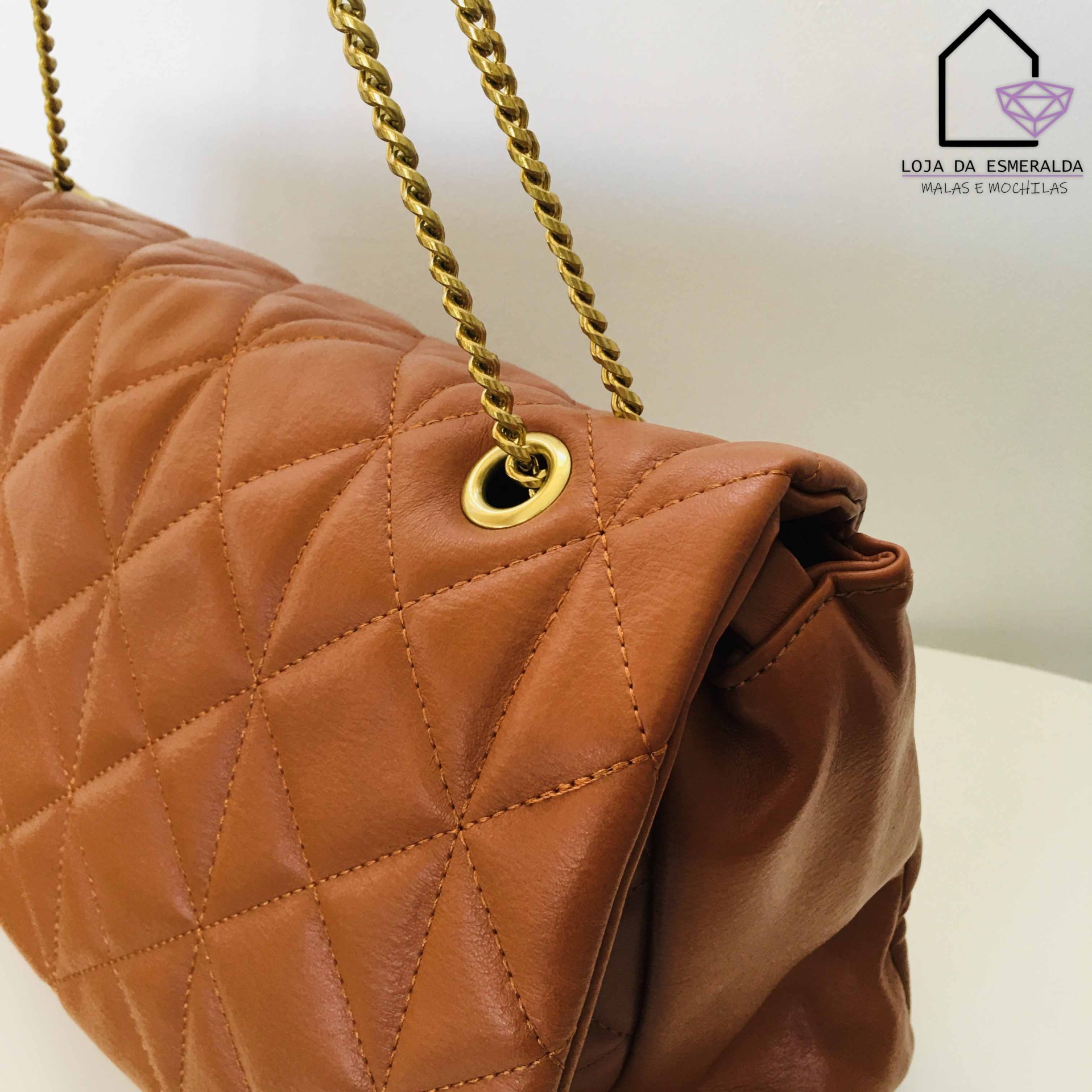 Mala de couro castanho com padrão de losangos e alças metálicas douradas