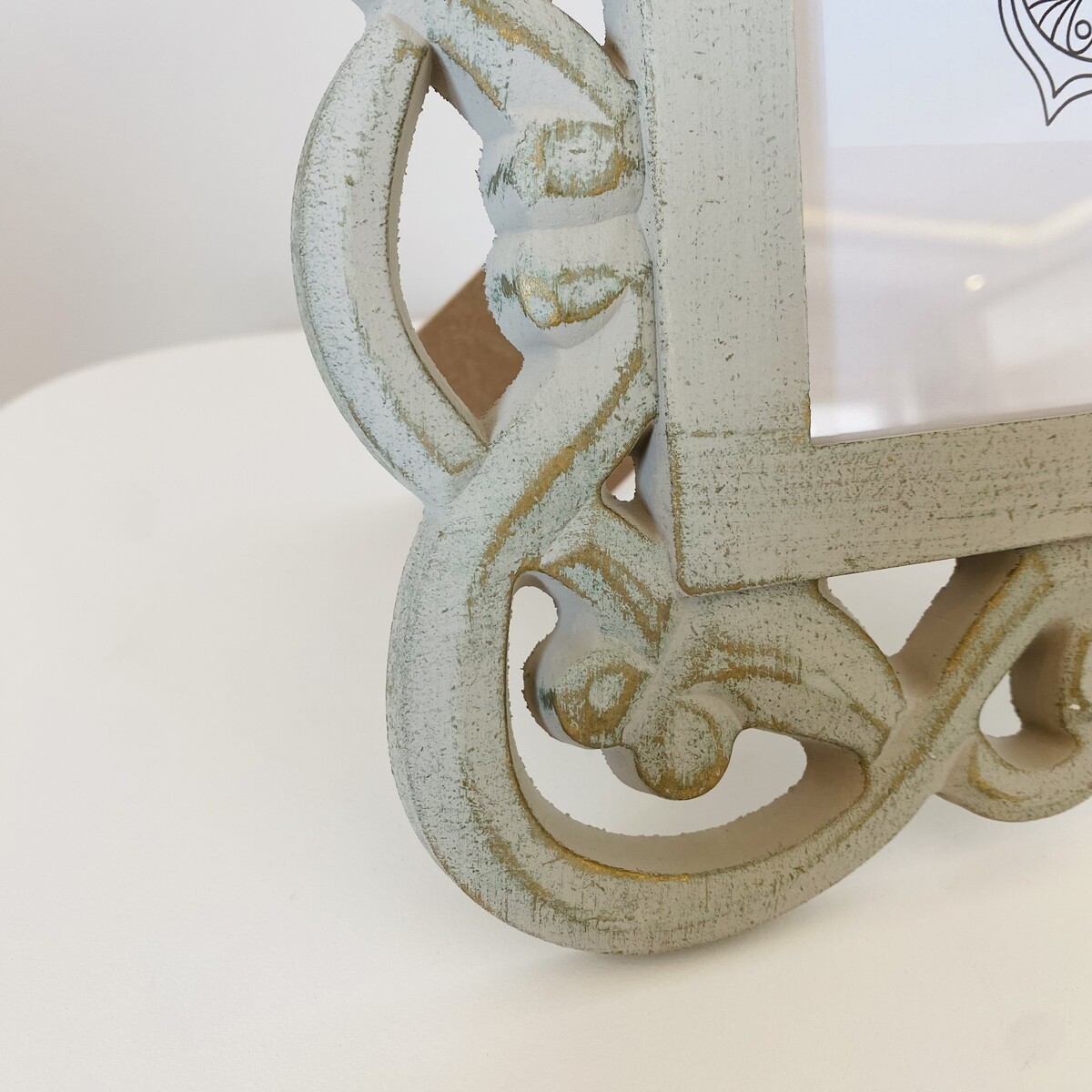 Canto decorativo de moldura branca envelhecida em madeira com detalhes entalhados