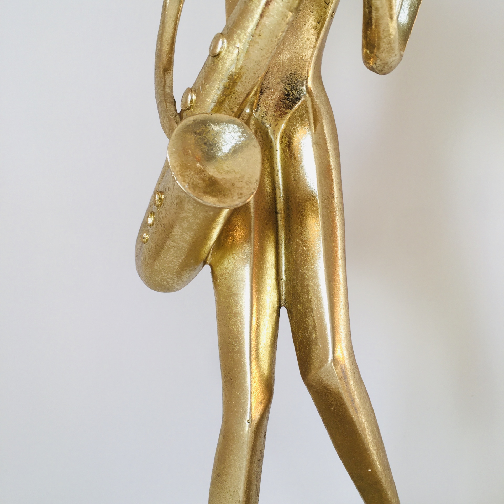 Estátua dourada abstrata de músico com saxofone