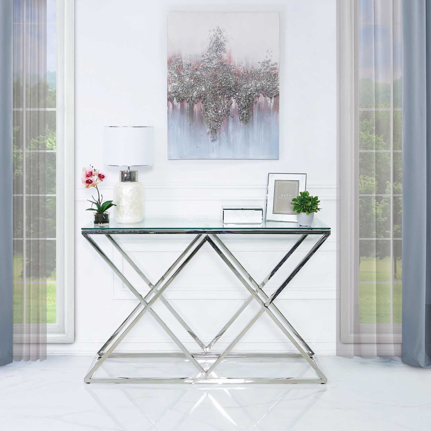 Mesa consola em vidro e metal cromado com decoração, quadro abstrato e flores