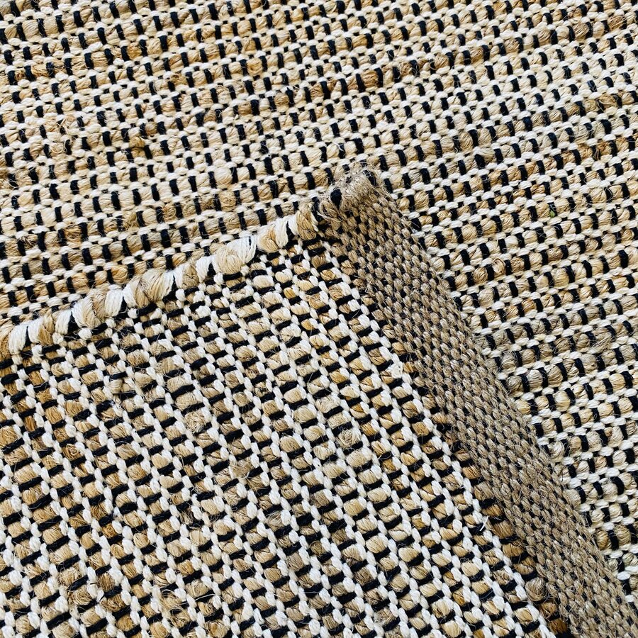 Tapete tecido com padrão geométrico bege, branco e preto dobrado