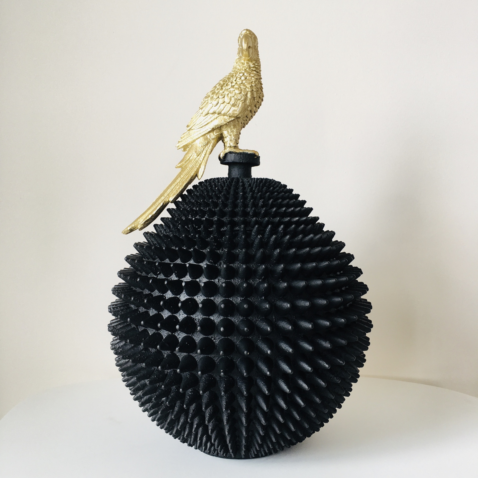 Recipiente decorativo preto pontiagudo com tampa de pássaro dourado