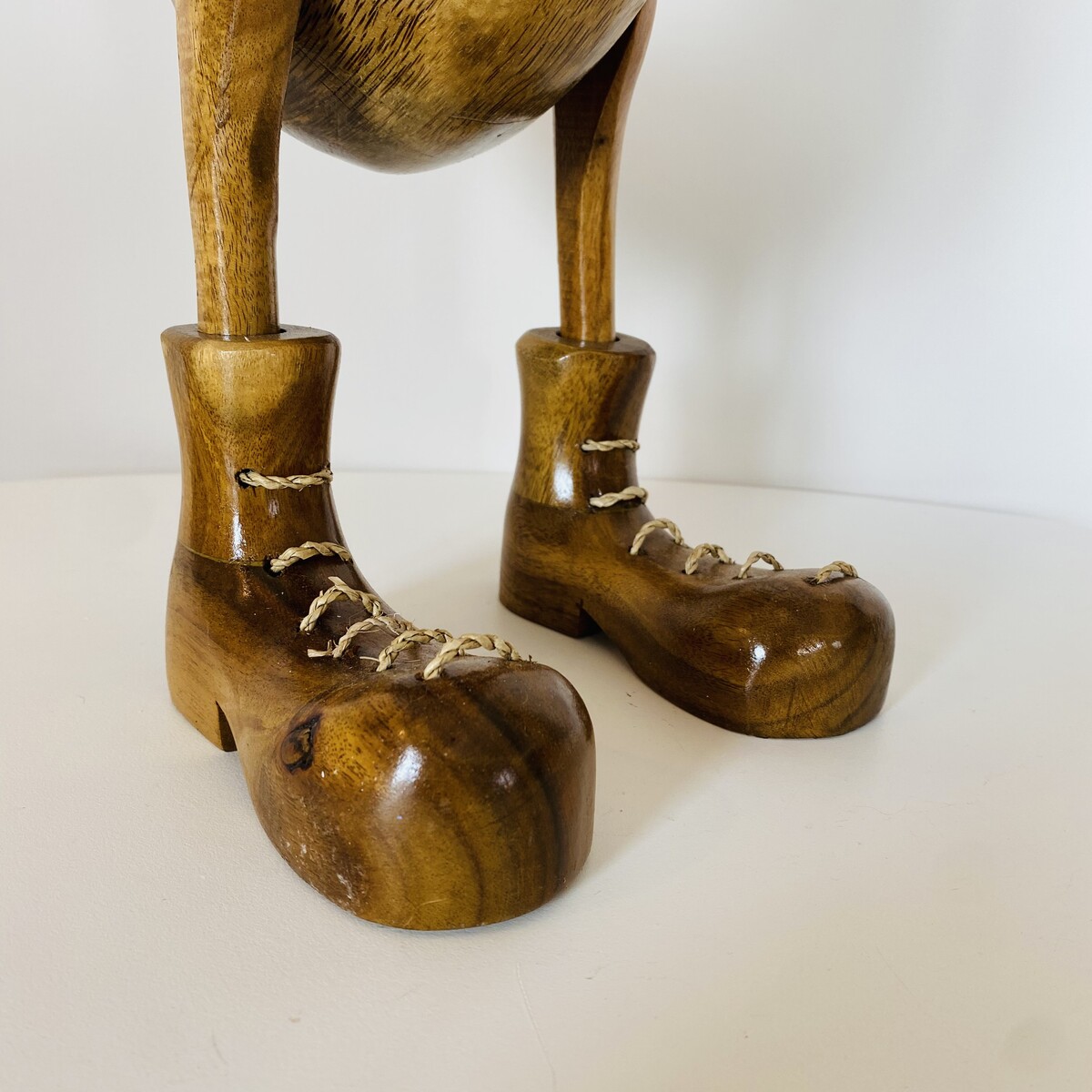 Pernas de escultura em madeira com sapatos e atacadores de corda