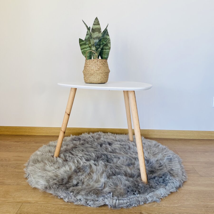 Mesa pequena branca com vaso de planta em tapete cinza peludo