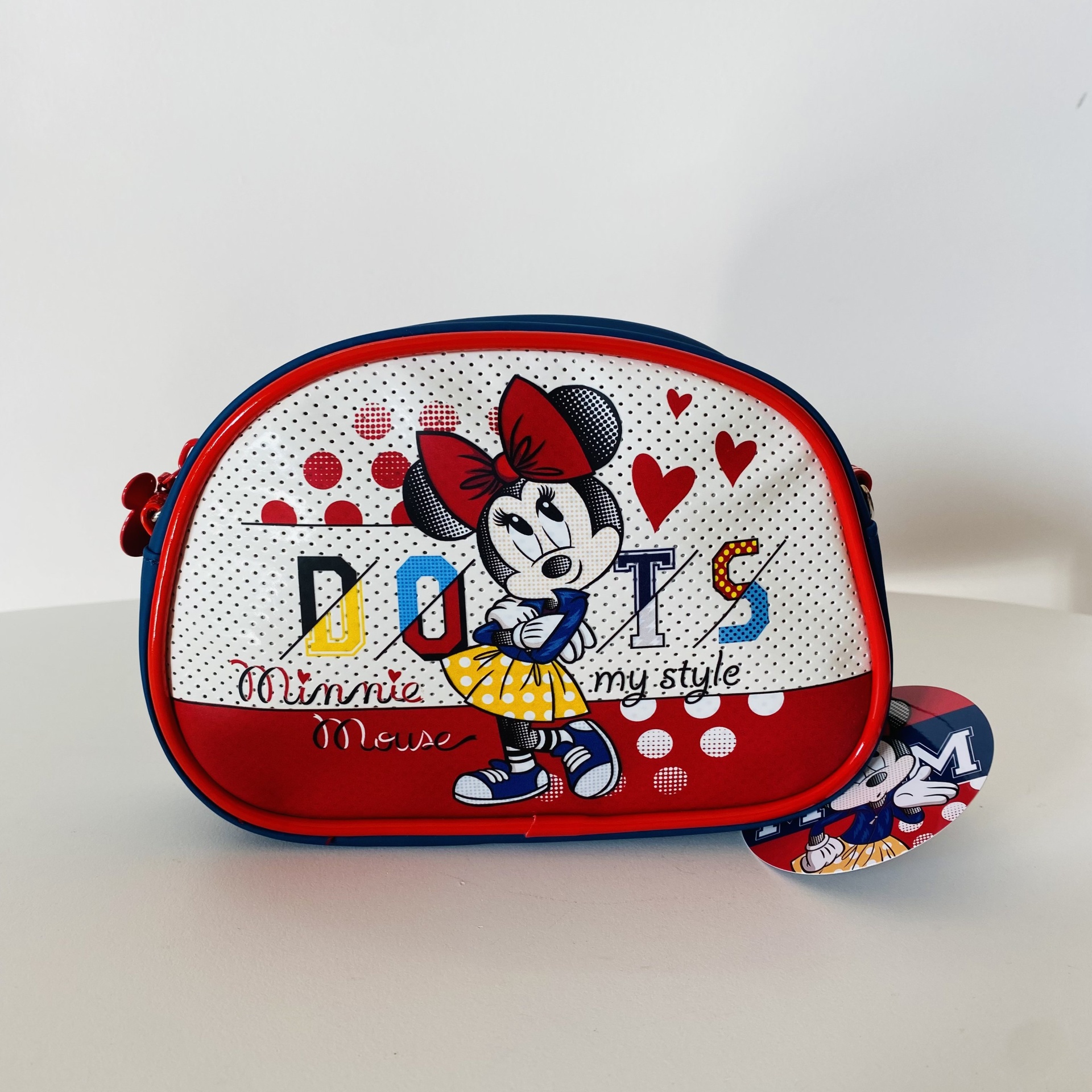Bolsa infantil com imagem da Minnie Mouse e texto em fundo branco e vermelho