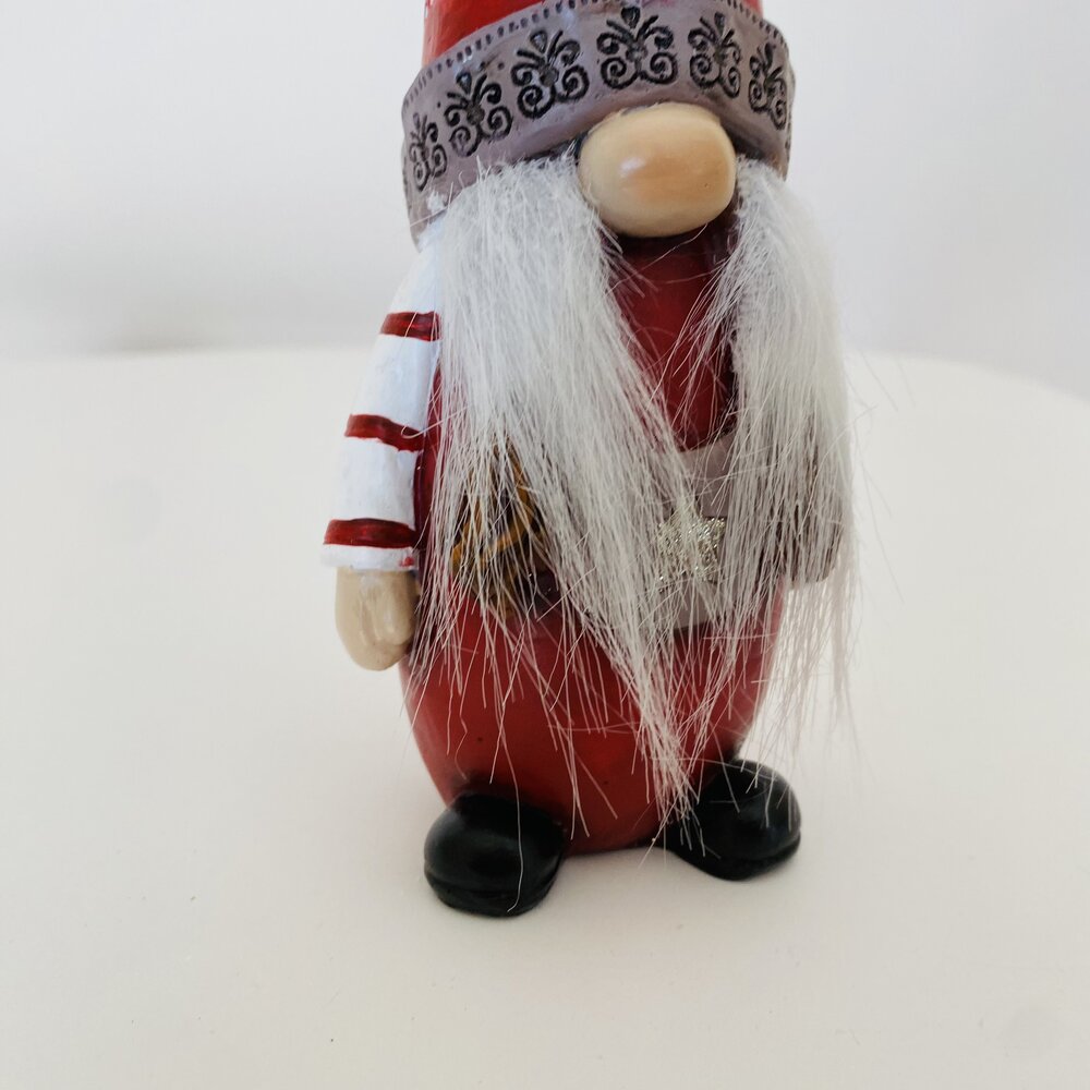 Figura decorativa de duende com corpo vermelho, barba branca e chapéu com padrão cinzento