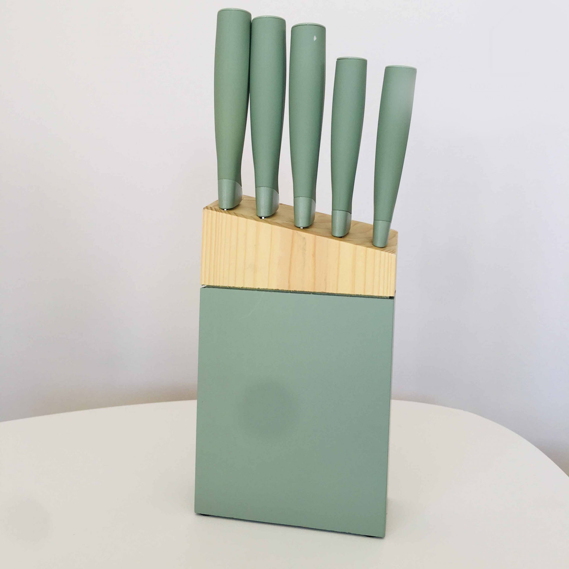 Conjunto de facas com cabo verde em bloco de madeira e suporte verde.