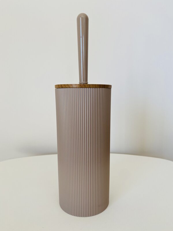 Suporte para escova sanitária bege com tampa de madeira sobre mesa branca