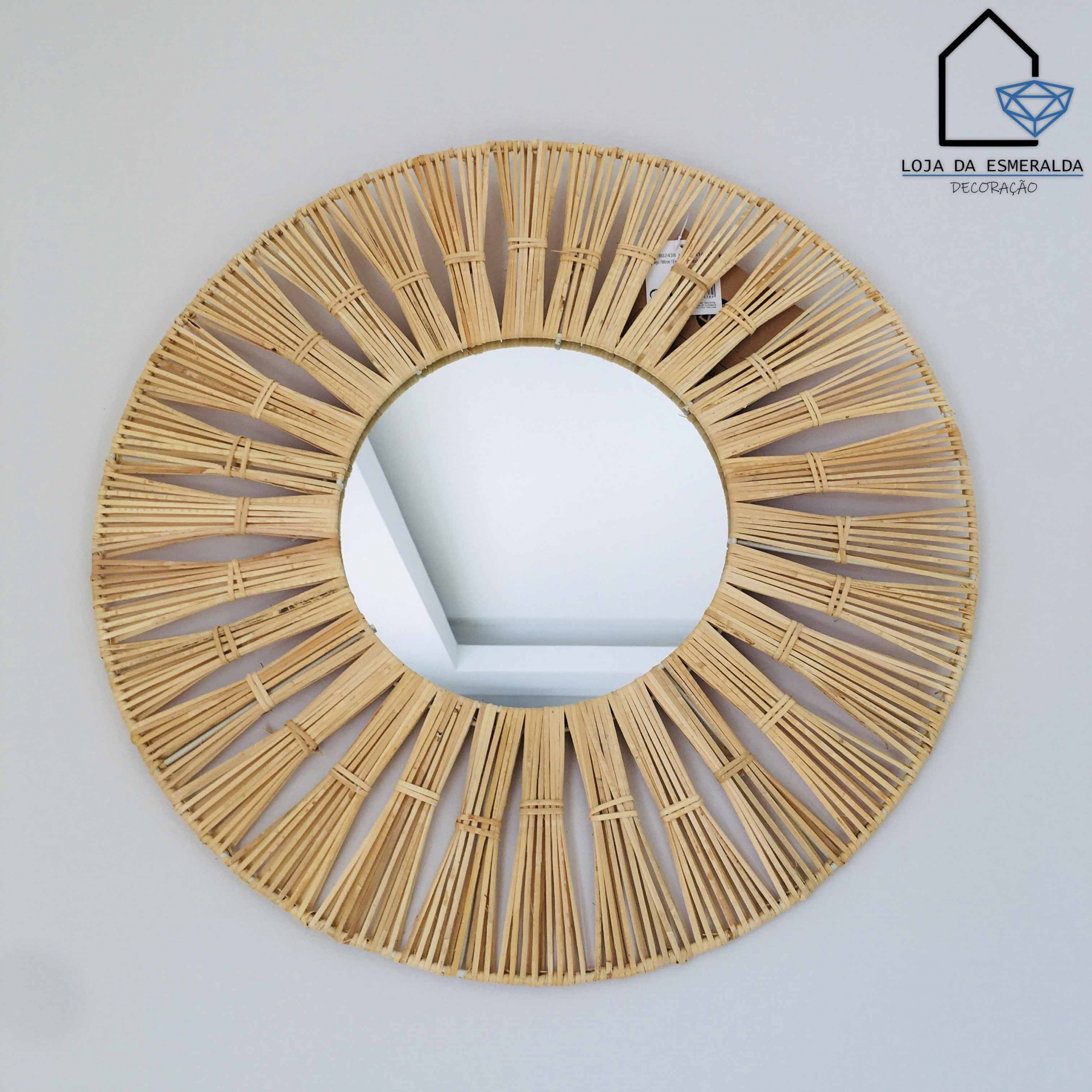 Espelho redondo com moldura de vime natural em parede branca