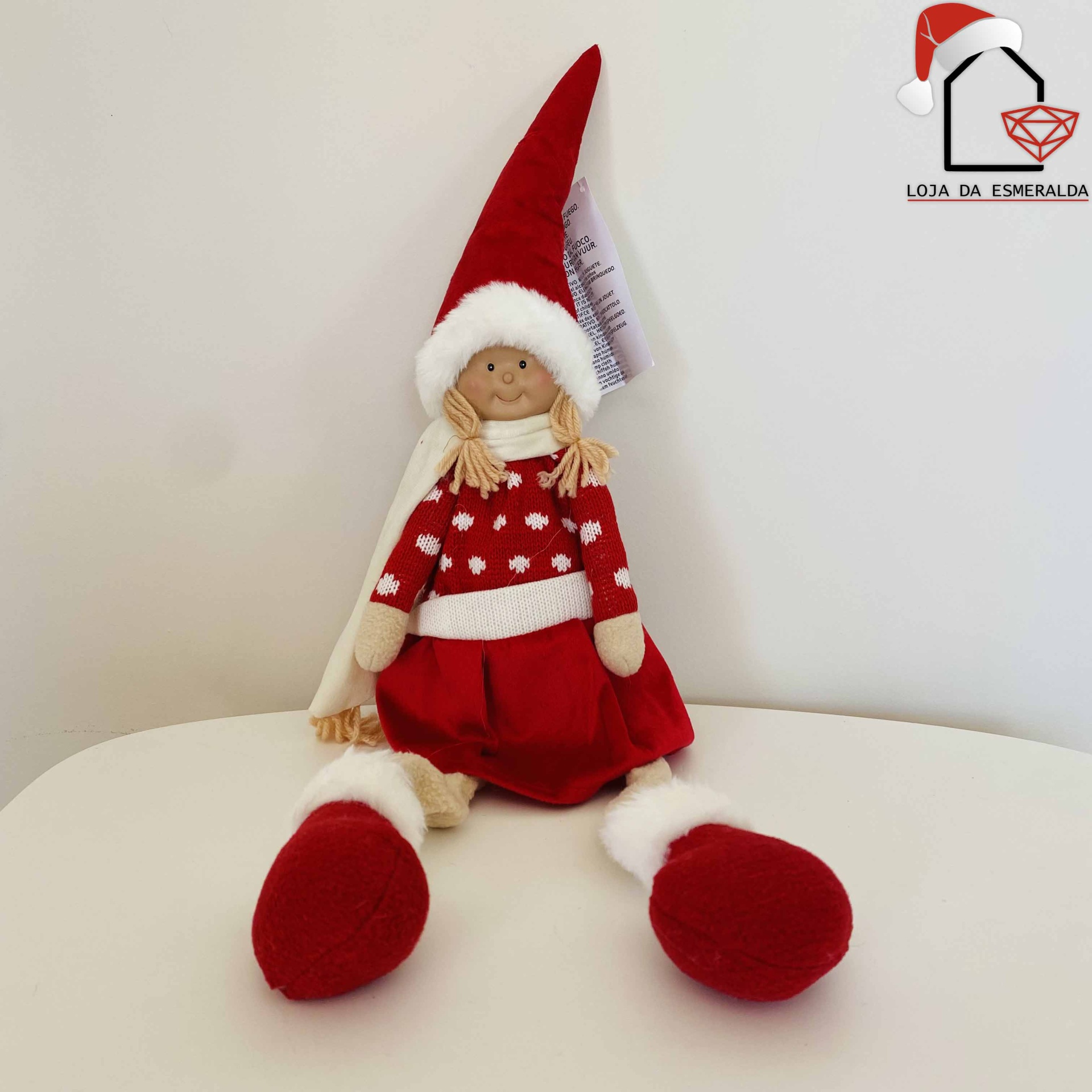 Boneca decorativa de Natal sentada com vestido e chapéu vermelhos e detalhes brancos