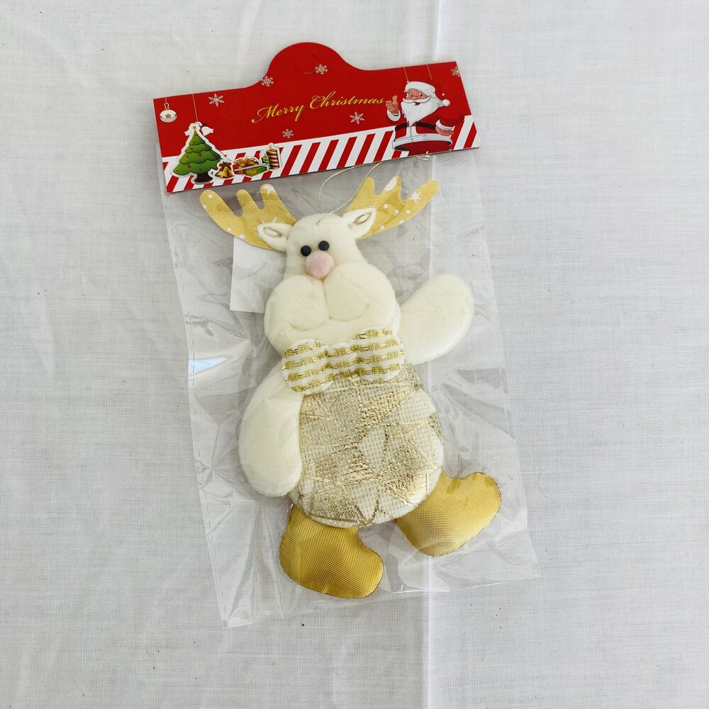 Boneco decorativo de rena de Natal em tecido branco e dourado numa embalagem com etiqueta vermelha e motivos natalícios