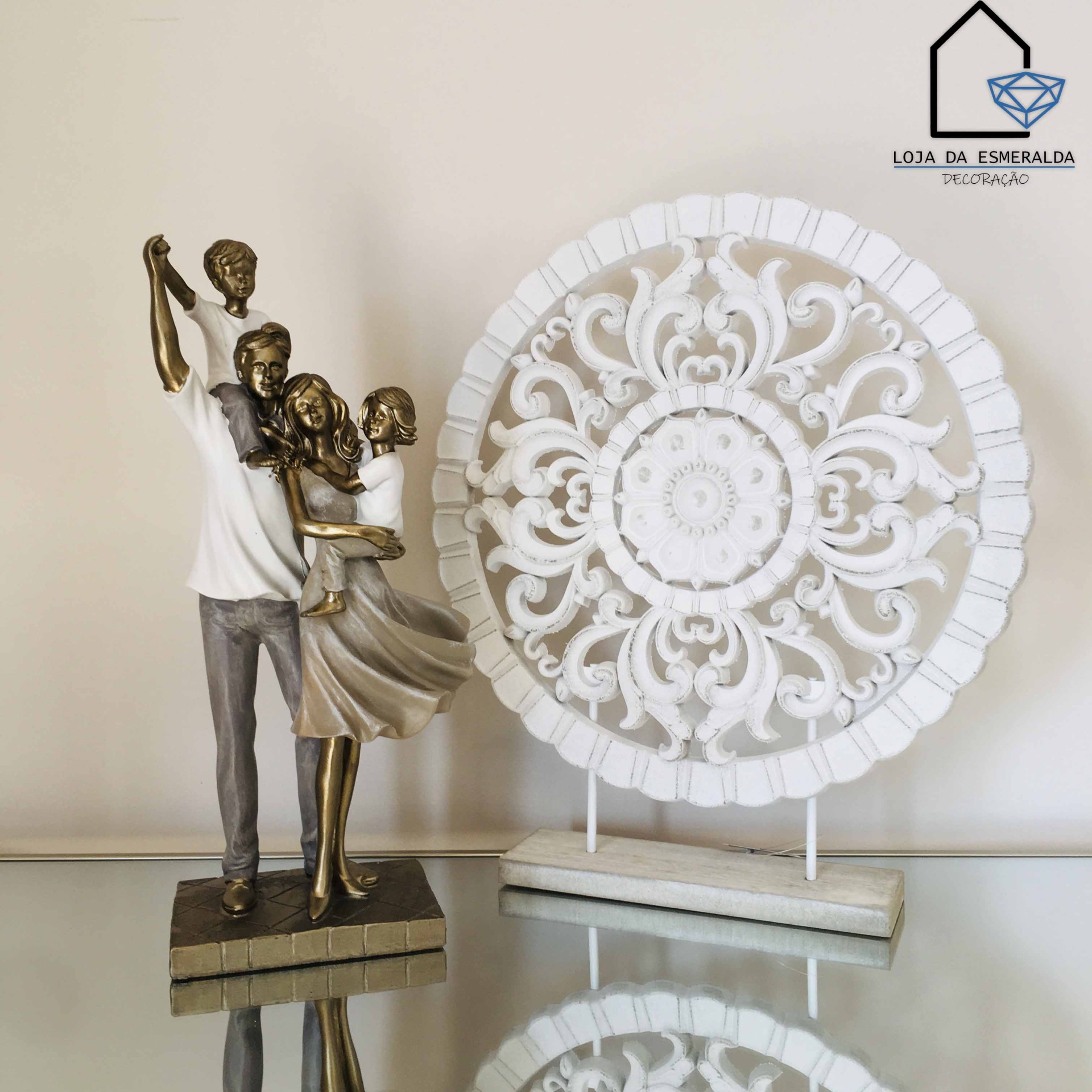 Estátua decorativa de família e peça decorativa redonda branca sobre superfície reflexiva