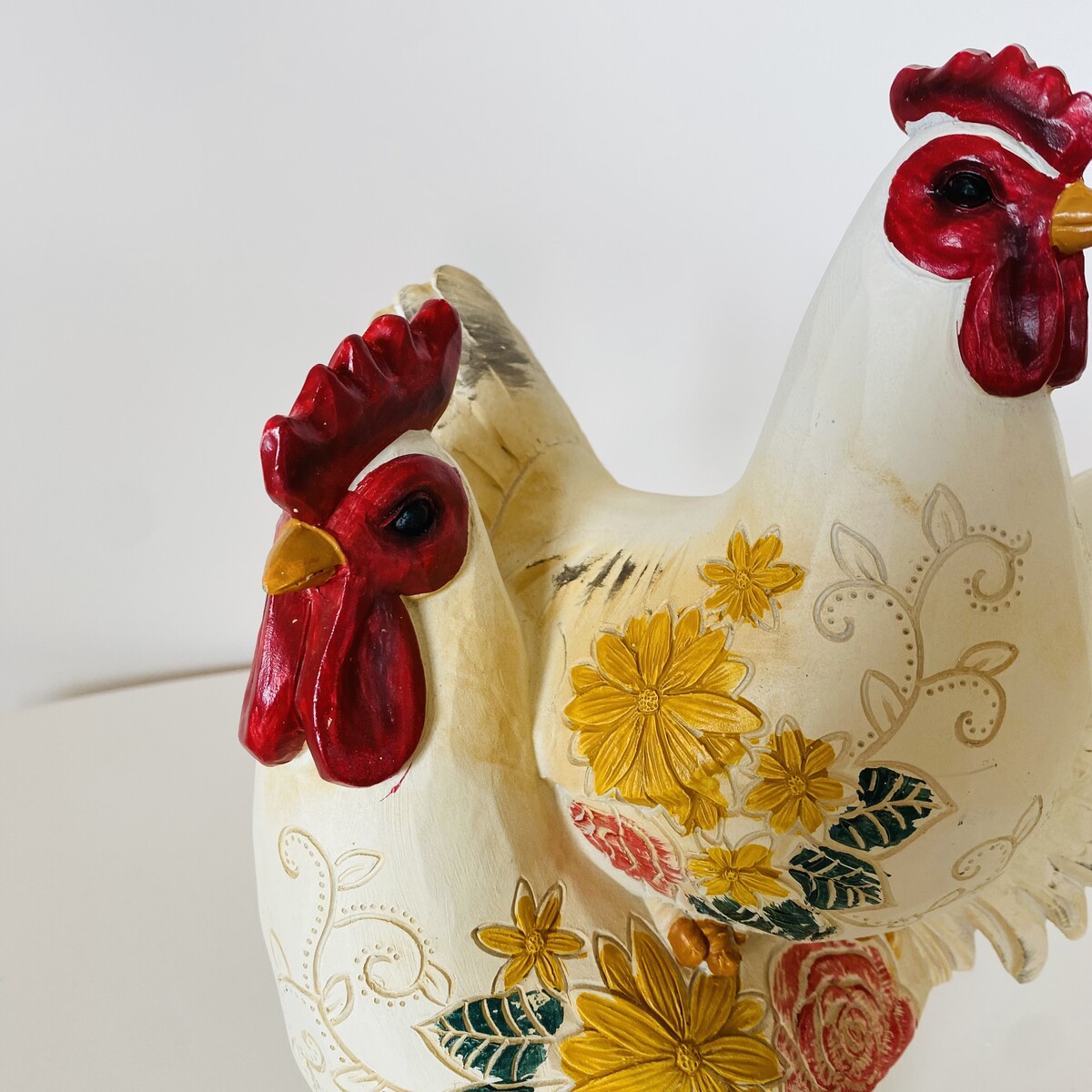 Estatueta decorativa de galinha branca com flores coloridas e detalhes vermelhos