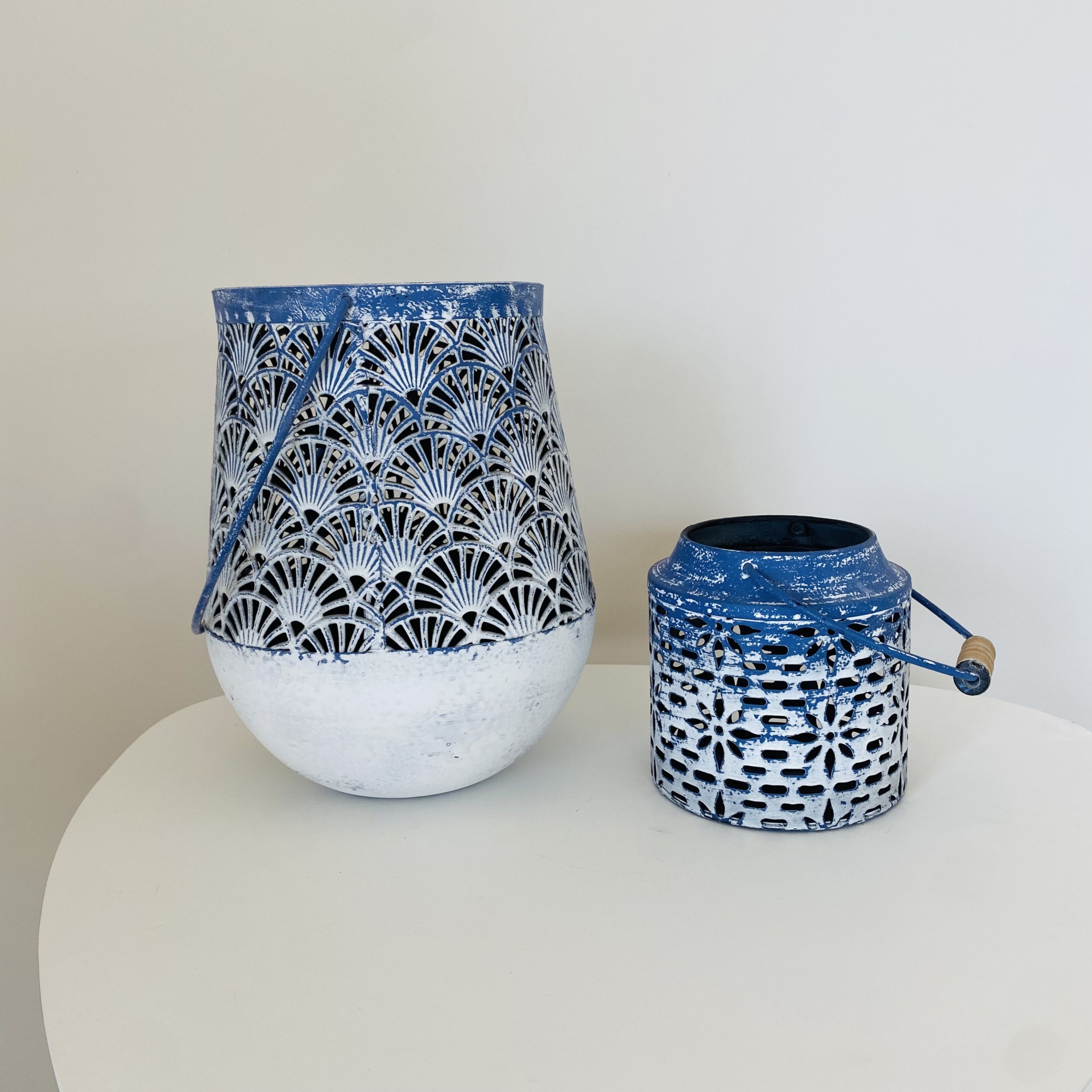 Dois candeeiros decorativos em metal branco e azul com padrão recortado