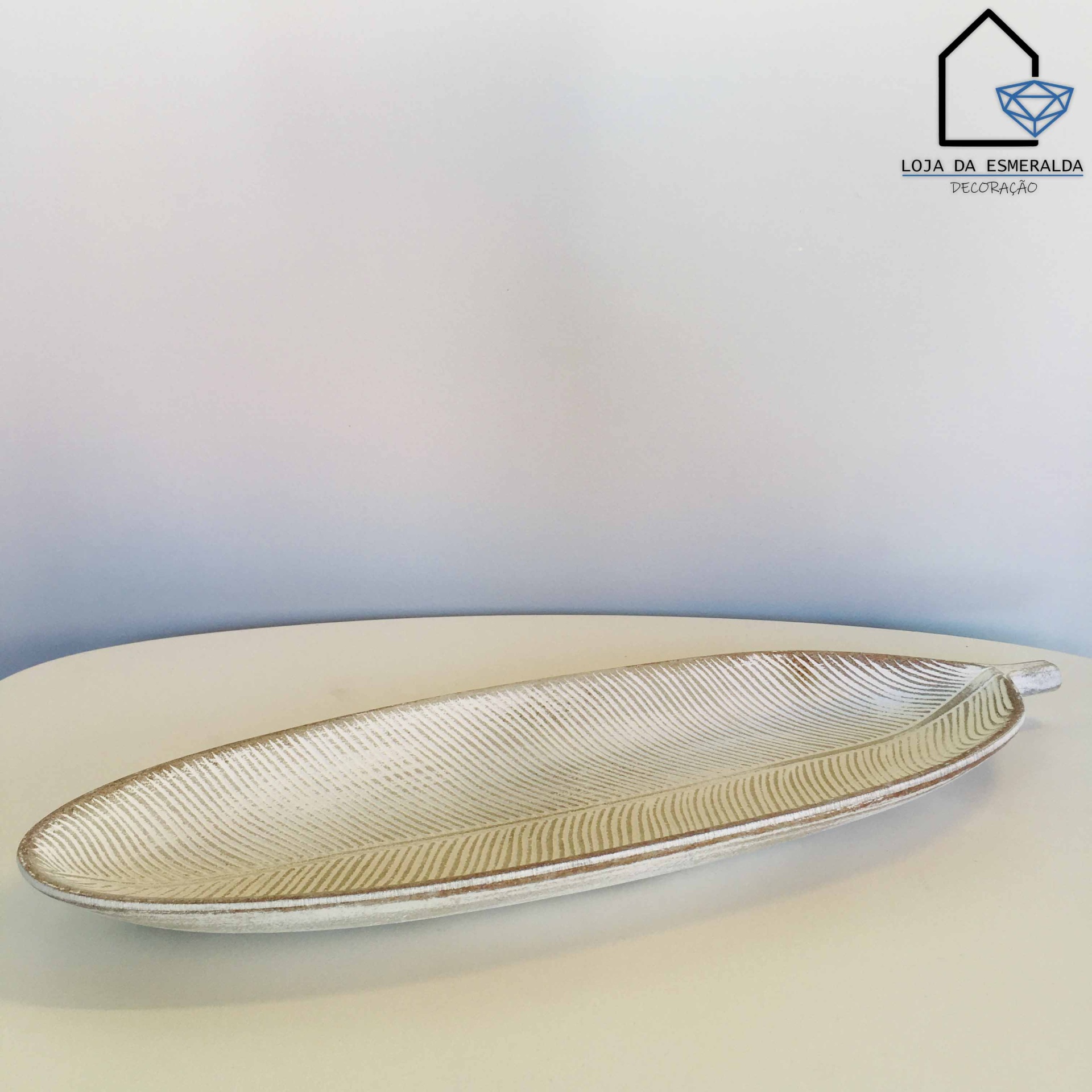 Prato decorativo em forma de folha branco com textura de veias sobre mesa branca