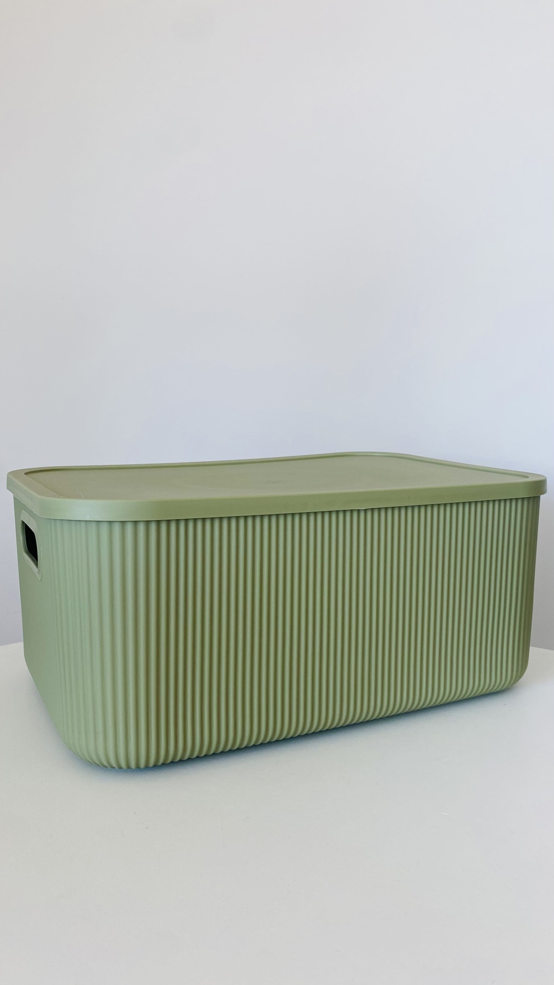 Caixa de arrumação verde claro com tampa e textura de ranhuras