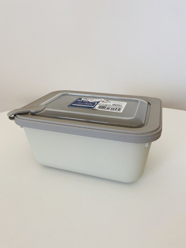 Recipiente plástico branco com tampa cinza e selo com texto e código de barras