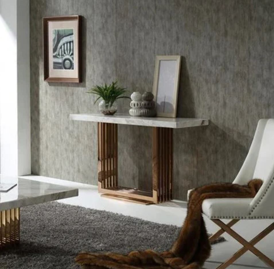 Consola de parede branca com base dourada e decoração, cadeira branca, parede cinzenta