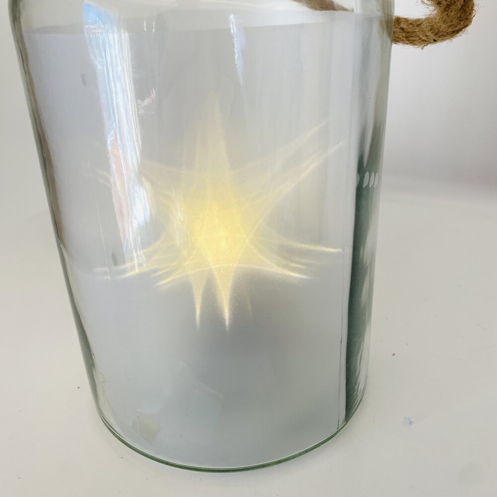 Recipiente de vidro com corda e luz amarela interior