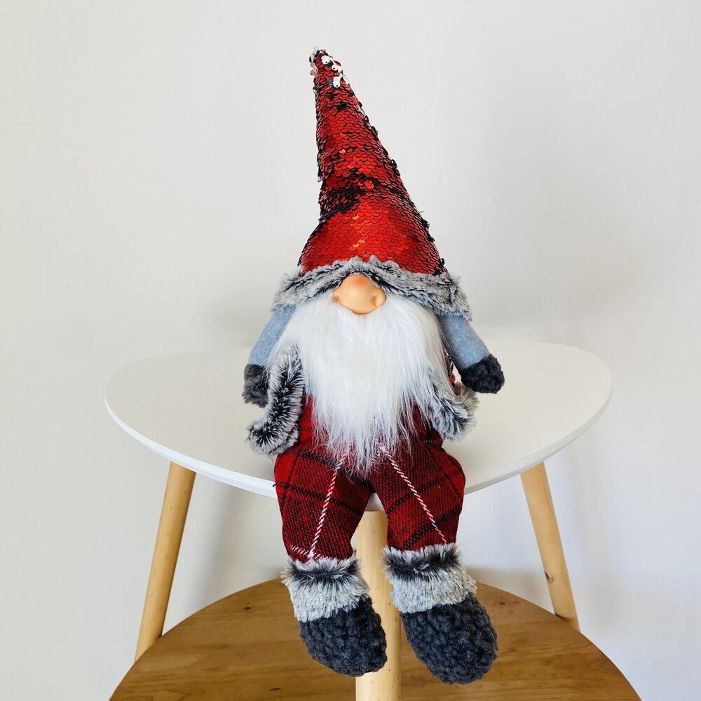 Boneco decorativo de Gnomo com roupa vermelha e azul sentado numa cadeira branca