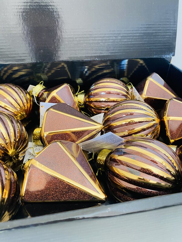 Enfeites de Natal dourados e castanhos numa caixa preta