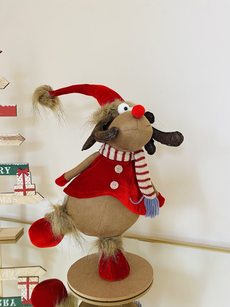 Boneco rena de Natal em tecido com gorro vermelho, casaco e echarpe às riscas, em fundo claro