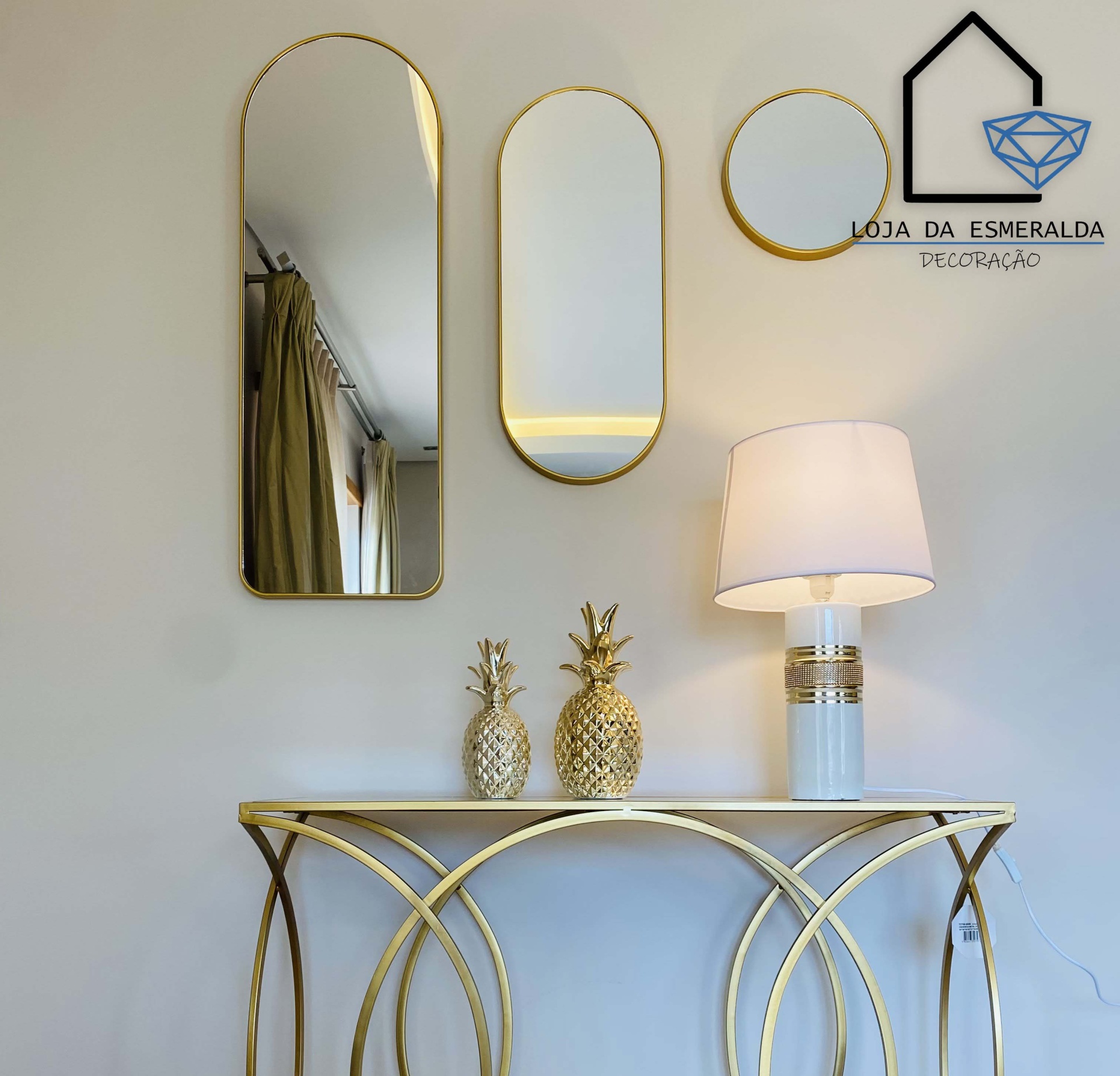 Espelhos decorativos dourados sobre consola dourada com decoração e lâmpada