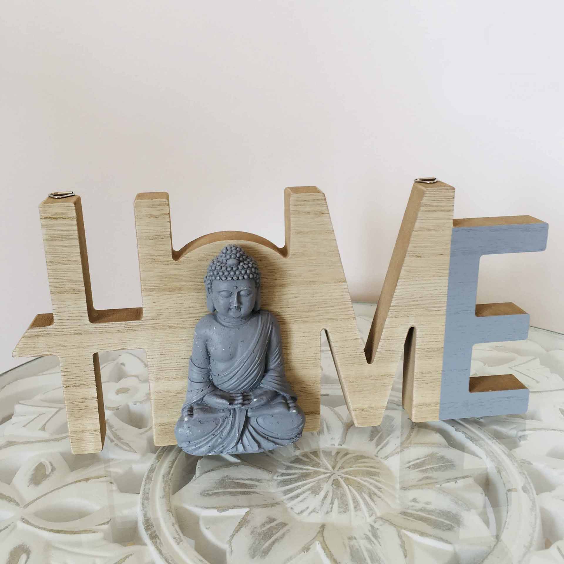 Decoração de madeira com palavra HOME e figura de Buda