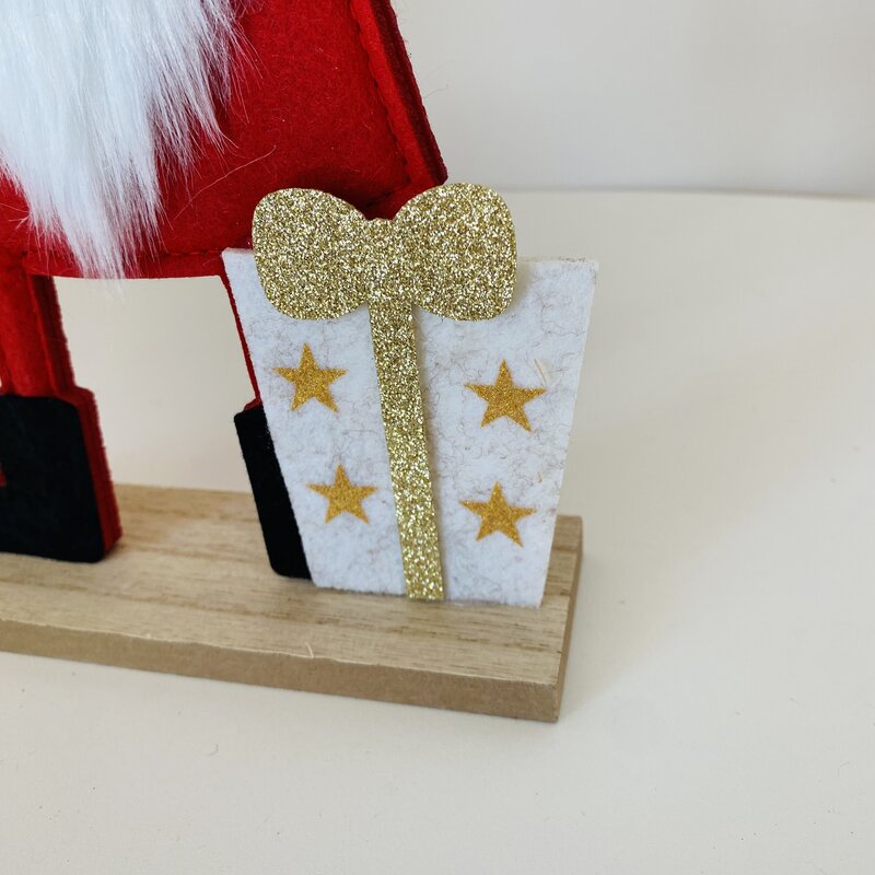 Decoração de Natal com presente branco e estrela dourada numa base de madeira