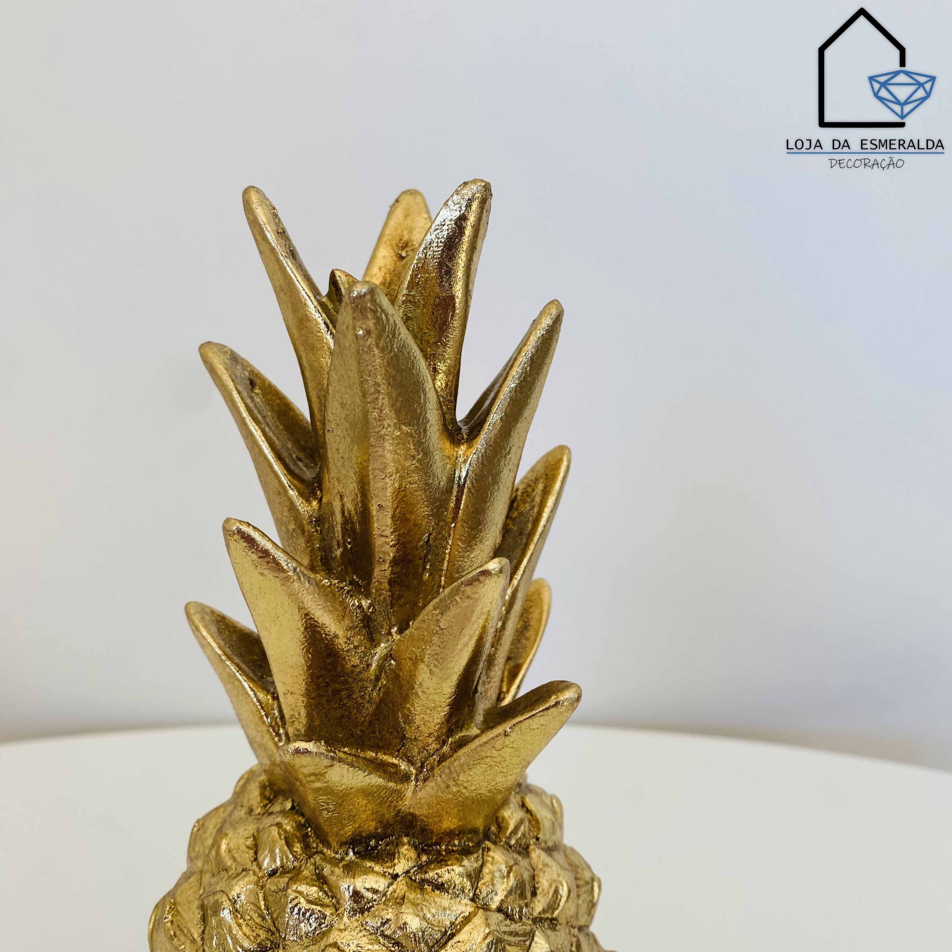 Escultura decorativa dourada em forma de ananás com textura detalhada