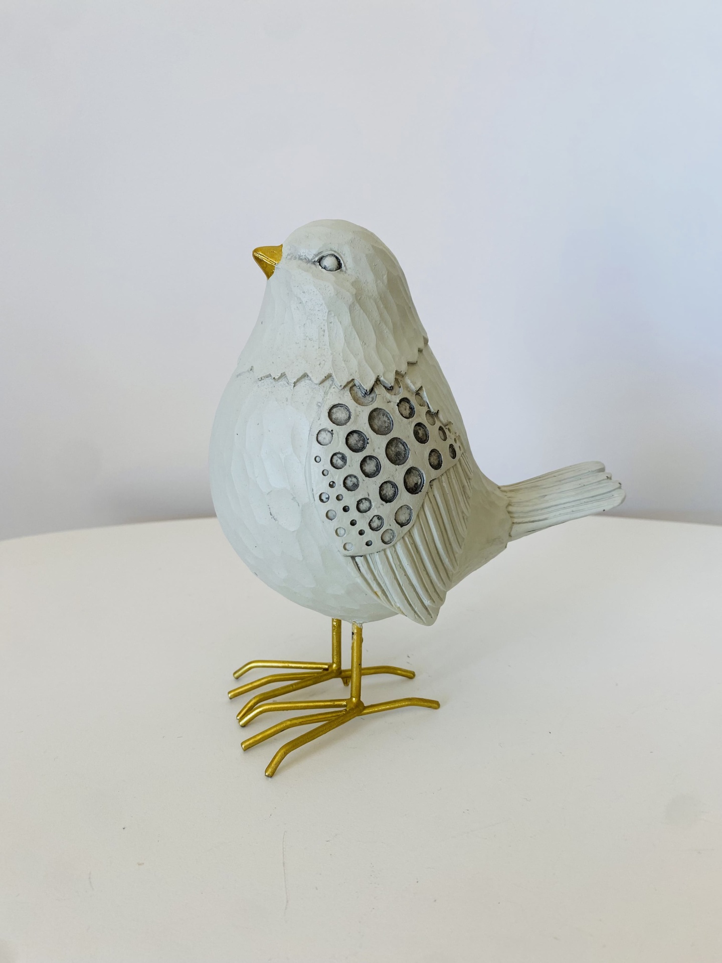 Estátua decorativa de pássaro branco com detalhes cinza e dourados